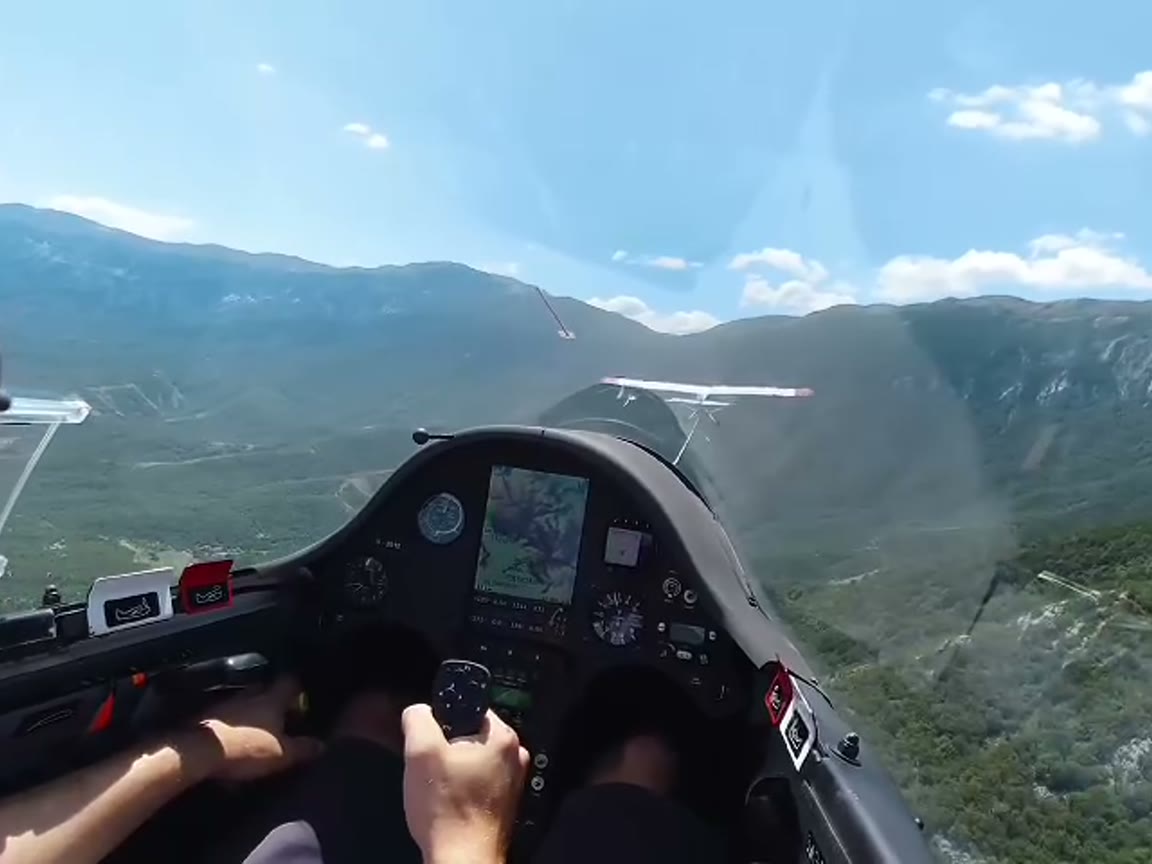 Pilot-eye view over green mountains from a small aircraft